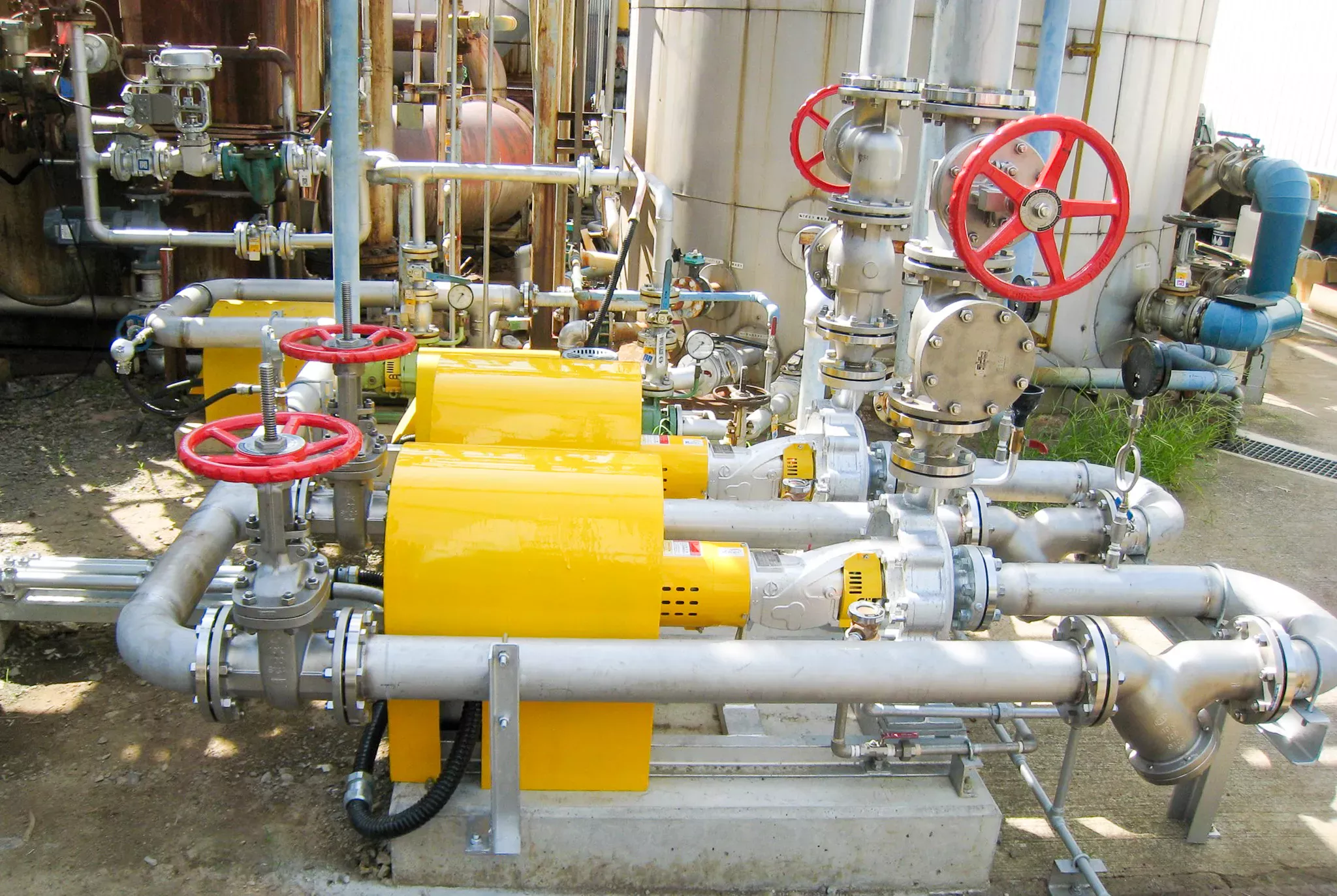 ボイラ給水ポンプの交換・設置完了。自社製作の黄色い保護カバーを装着し、耐久性と視認性を高めた最新の給水システム